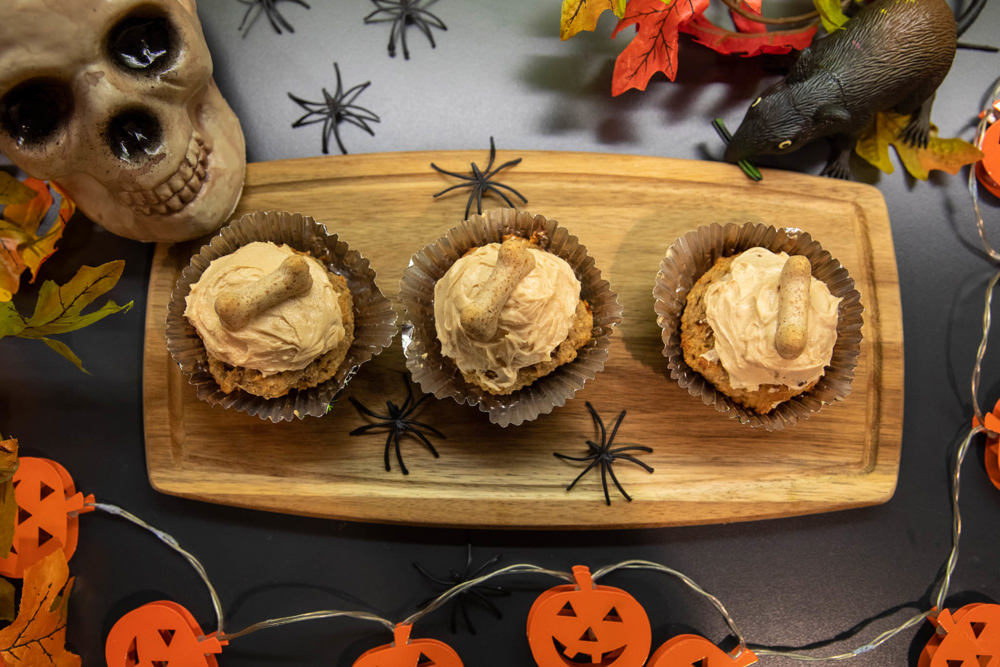 3 treats on a wooden board, Halloween themed background